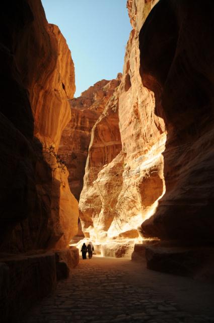 people walking between mountains