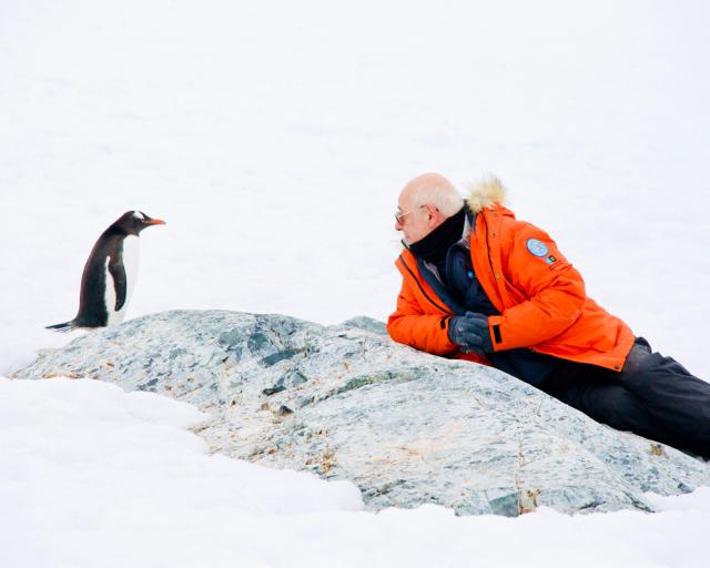 Male and penguin in the snow