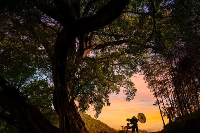 two people standing in front of sunset