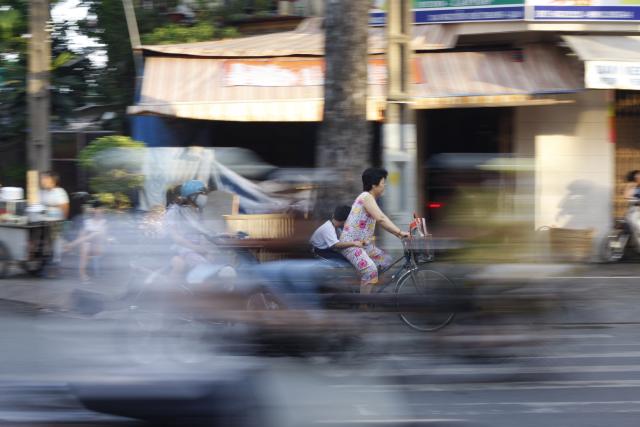 Blurry image of adult and child on bicycle