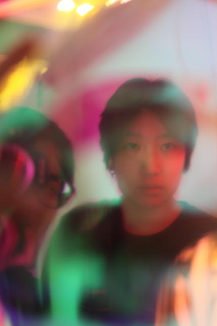 Colorful portrait of two people behind cellophane.