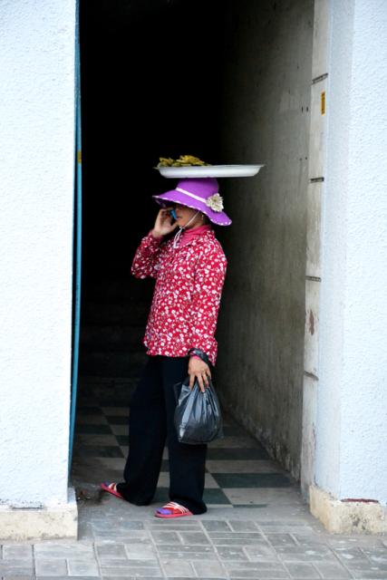 colorful dressed lady with dish on her head