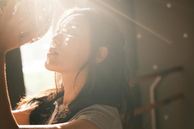 Backlit closeup of woman.