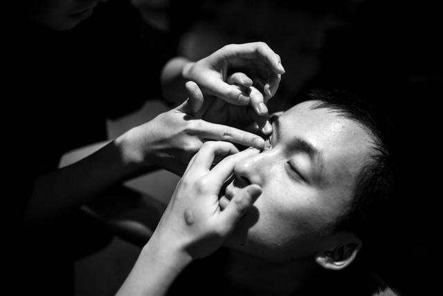 Person helping person put contact in