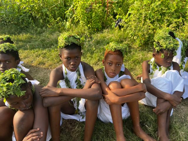 Children in Accra wearing white tunics and leaves on their heads.