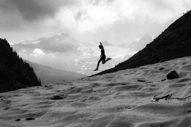 Silouhette of male running down mountainside.