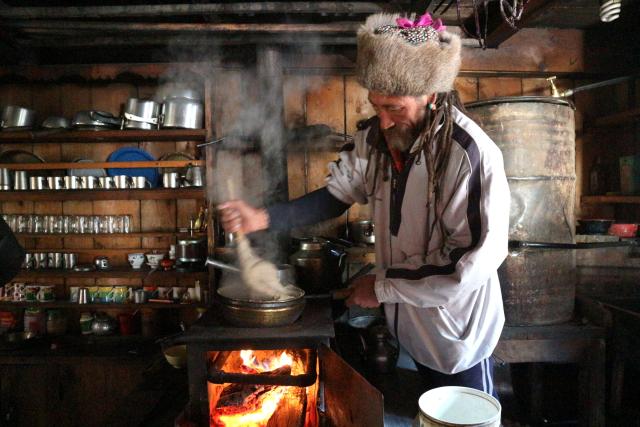 Man cooking over a fire in his hut