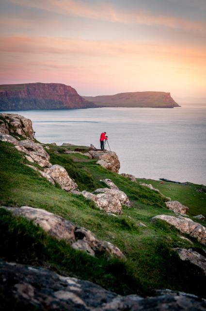 Man in the distance setting up a camera over looking a large body of water