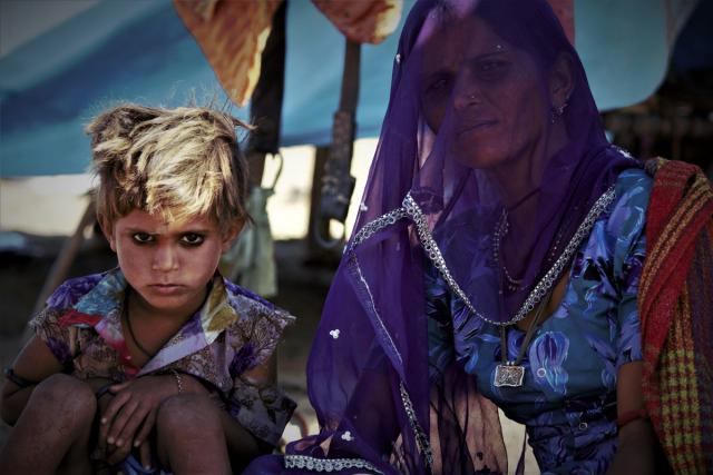 Daughter and mother outside of a tent in India.