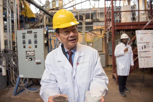 Scientist with hard hat holding material samples