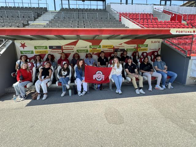students holding an Ohio State flag at a football stadium