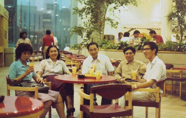 Photo of individuals sitting around a dining table