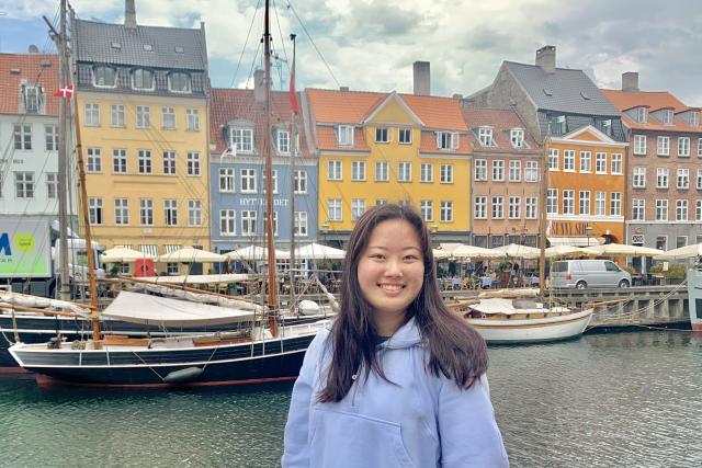 Young woman smiling in front of scandanavian canal