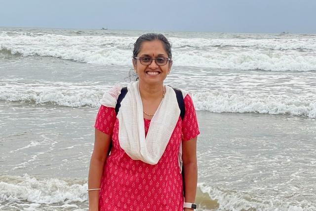Female standing near large body of water with waves