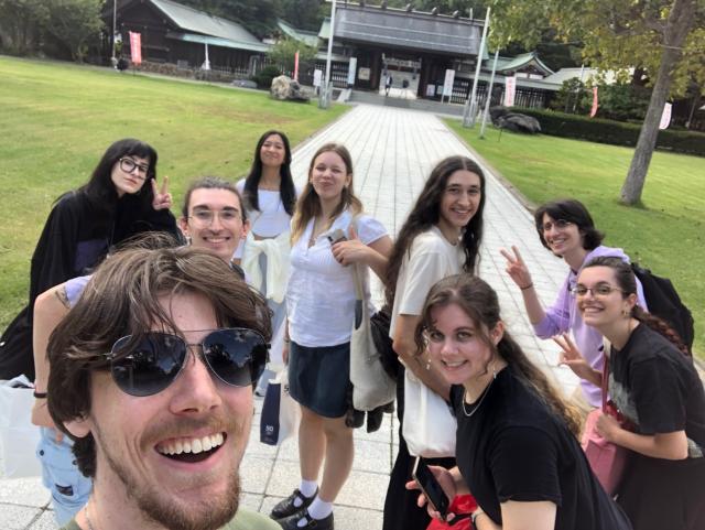 Group selfie of students with Japanese temple in background