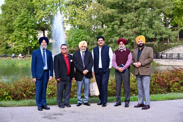 Group of men pose in front of Mirror Lake.