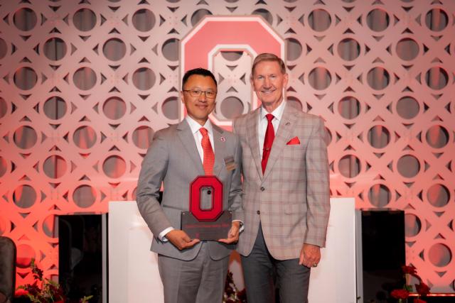 Two men dressed in suits at awards ceremony on stage