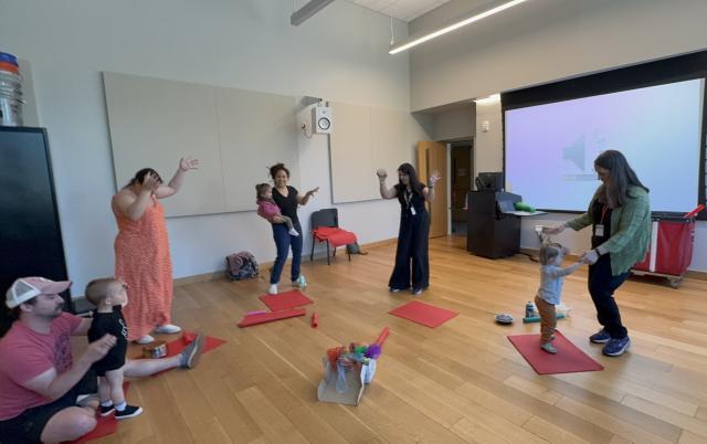 Teachers with infants and parents dancing to music.