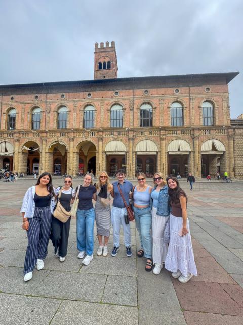 Eight students pose in piazza in Bologna