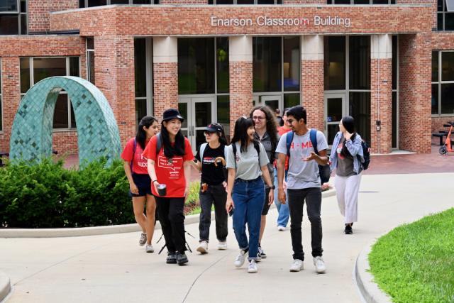 Group of students walking outside of campus building.