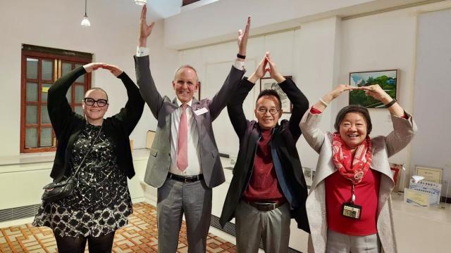 Four people spell out O-H-I-O with their arms.
