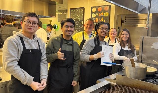 Men and women wearing aprons in a kitchen