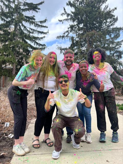 Smiling people with colorful paint on their shirts and bodies