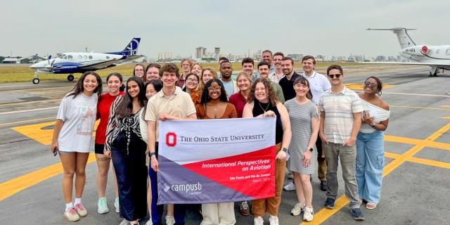 Group holding flag in front of planes