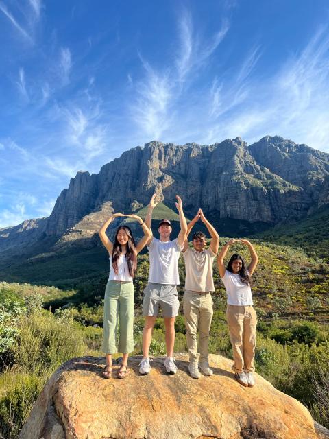 students doing O-H-I-O in front of a mountain