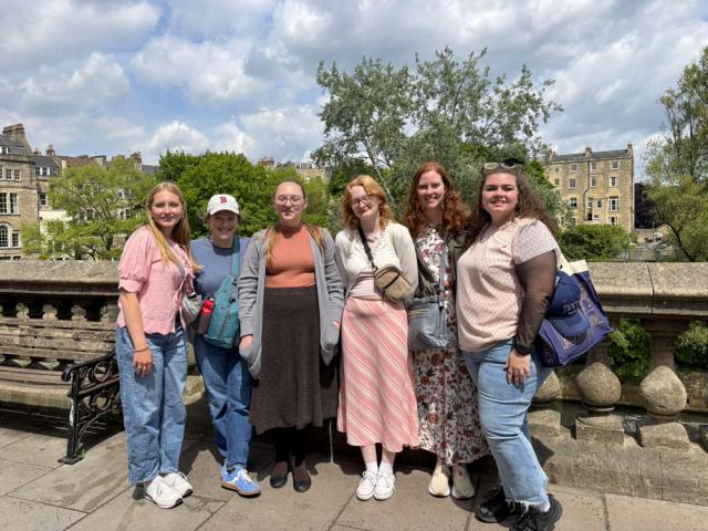 Six women pose outside