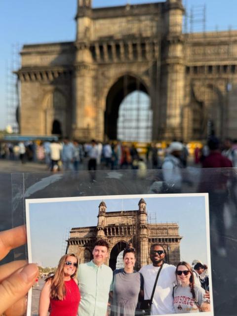 Printed photo of students held up in front of gate in India