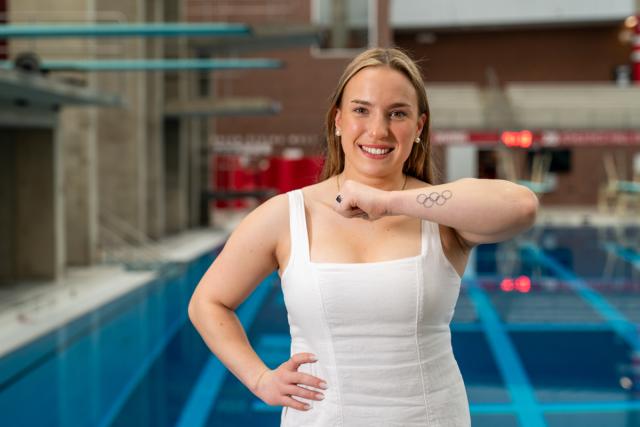 Woman shows tatoo of Olympics rings are her forearm.