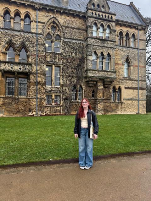 Student behind an old stone mansion