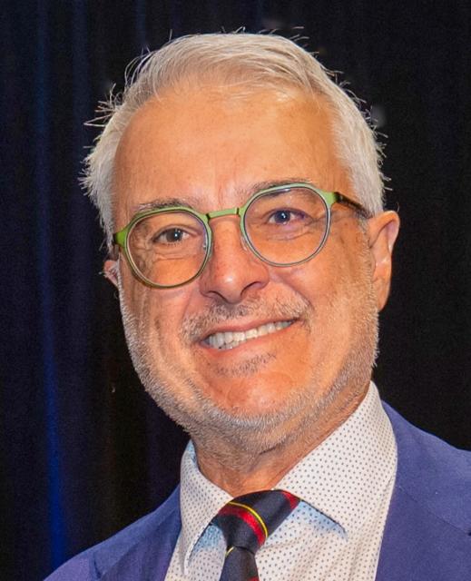 Headshot of male wearing glasses and tie.