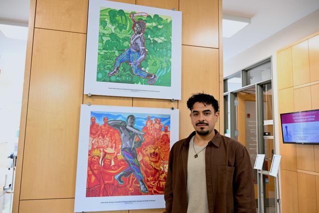 De Paz poses by two of his artworks in the gallery.