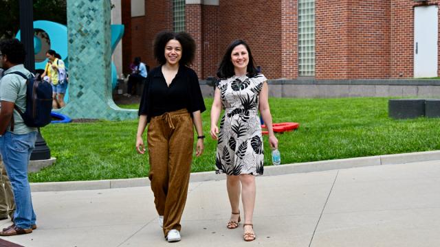 Two woman walk on university campus.