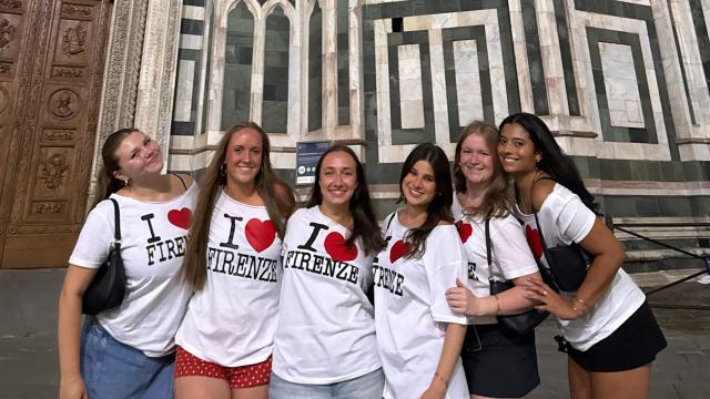 Students in matching shirts in front of building