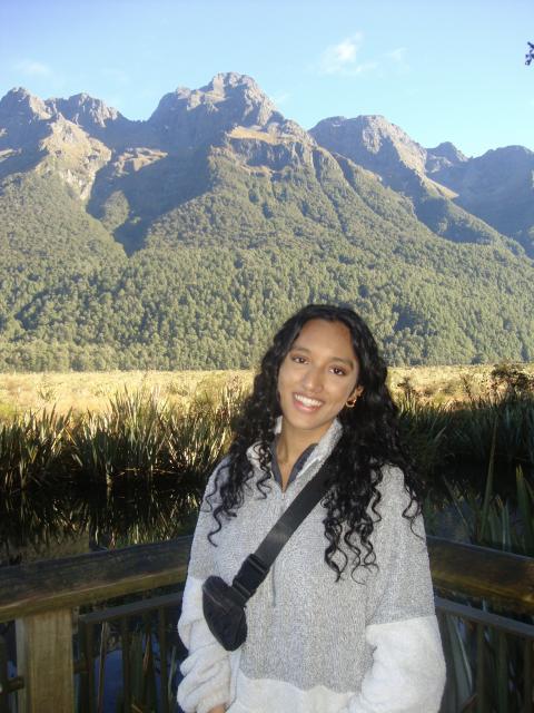 Student overlooking a field with mountains in the background