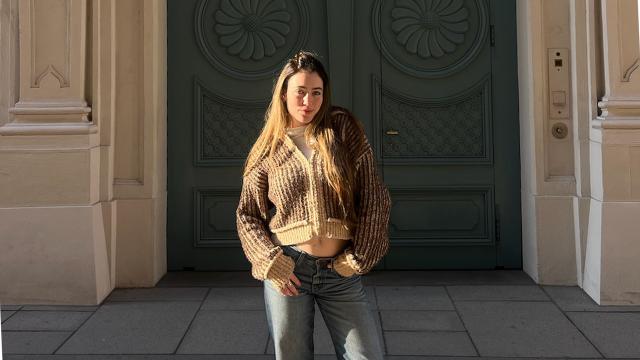 student in front of green doors