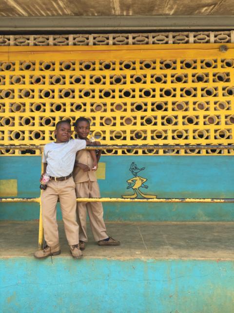 Two boys standing in front of bright colored wall