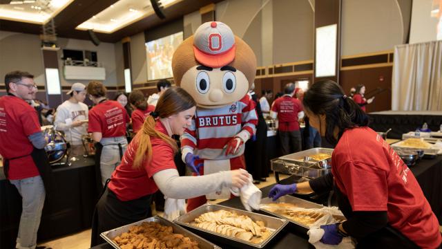 Brutus Buckeye serves food at Thanksgiving Dinner