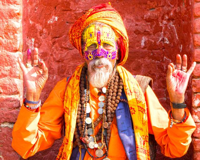 Nepalese mystic poses for portrait in colorful clothing.