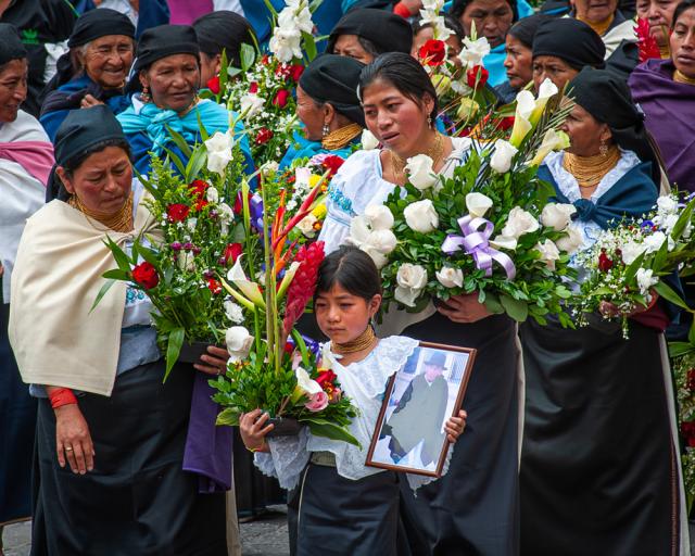 Women and girl show their grief during funeral procession.