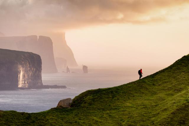 Male climbs mountain in the distance.