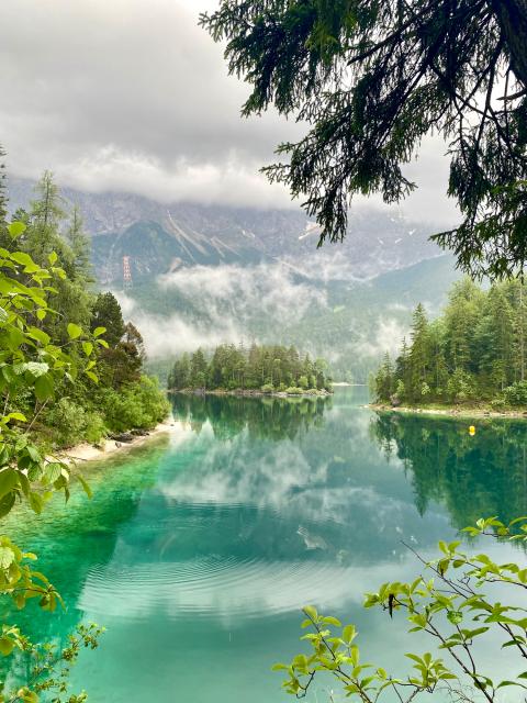Lake with green and blue water with mountains in background
