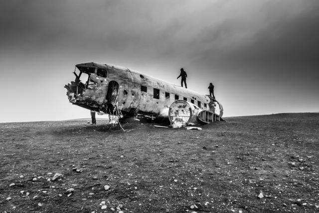 two people walking on destroyed airplane