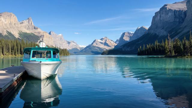 Boat docked on a lake with mountains in background