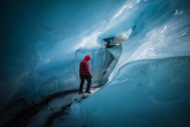 Person hikes inside an ice cave