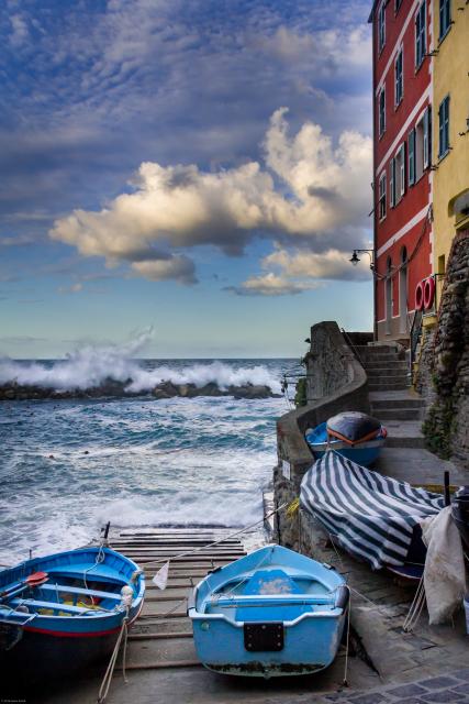 Waves crashing into a dock next to an Italian villa