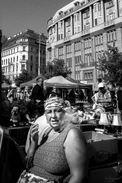 Older woman smoking a cigarette at the market.